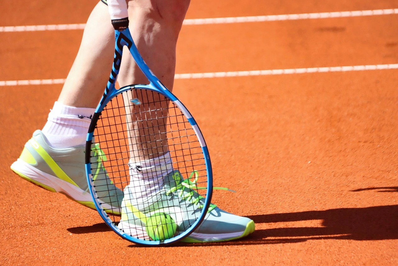 tennis racket with a tennis ball on a mans leg