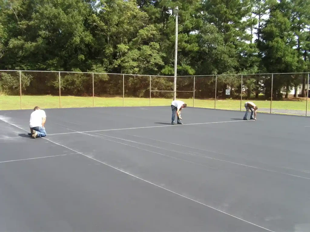 newly resurfaced tennis court with crew preparing court lines